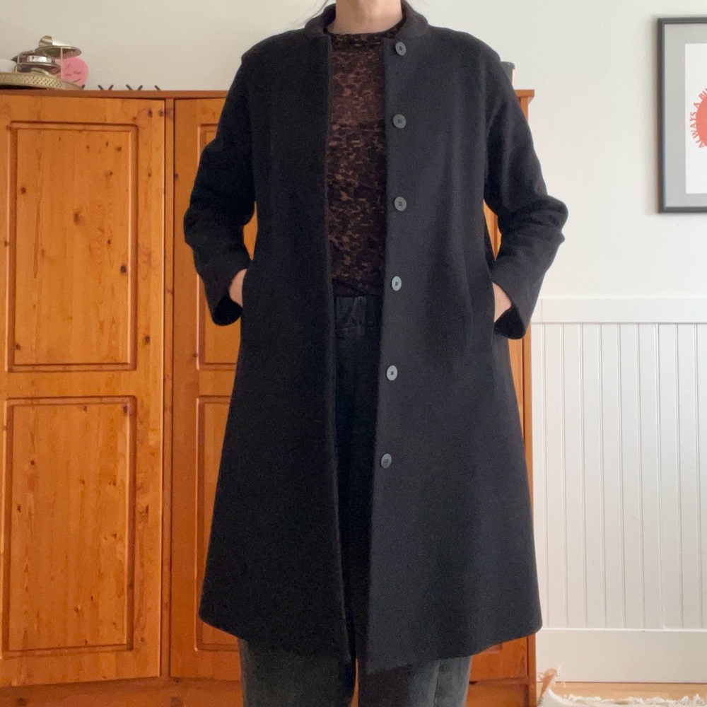 Minimal COS black wool coat with hidden button placket and bomber collar